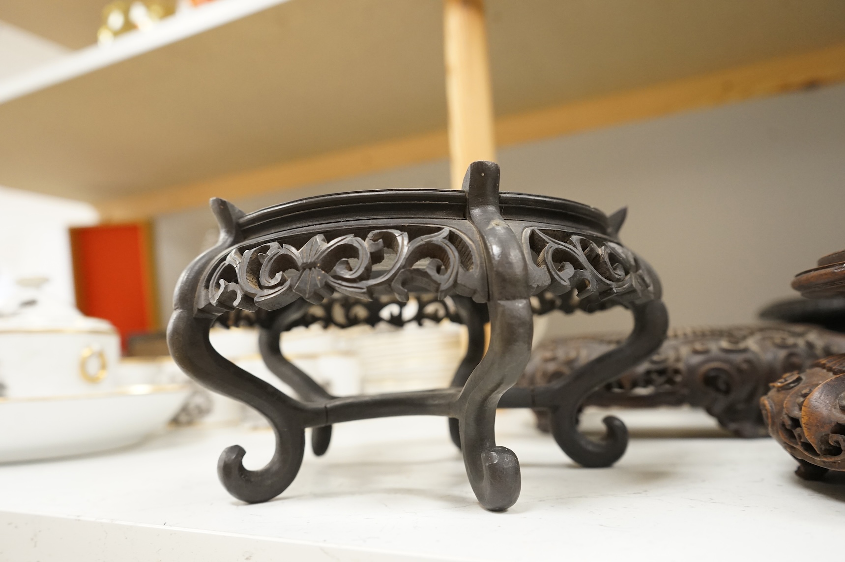 A collection of five Chinese and Japanese carved hardwood stands, late 19th/early 20th century, largest 25cm in diameter
